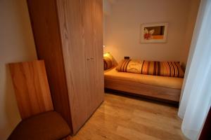 a small bedroom with a bed and a chair at Landhaus Alpenflair Whg 403 in Oberstdorf