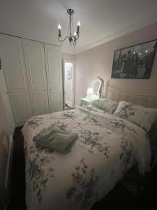 ein Schlafzimmer mit einem Bett und einem Kronleuchter in der Unterkunft Cluaine Meala cottage in Isleworth