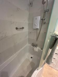 ein Bad mit einer Badewanne und einer Dusche mit einem Waschbecken in der Unterkunft Cluaine Meala cottage in Isleworth + 18 Fotos