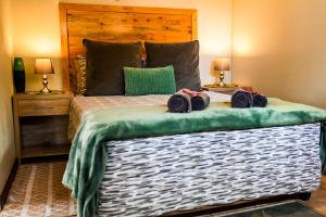 a bedroom with a bed with towels on it at Old Roastery Cottage in Bloemfontein