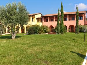 duży dom z trawnikiem przed nim w obiekcie Le Corti Del Sole Residence w mieście Venturina Terme