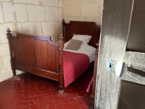 - une chambre avec un lit en bois et une couverture rouge dans l'établissement La Maison des Hautures, à Arles