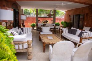 a patio with white couches and a table and chairs at The House on The Sand - Malindi in Malindi