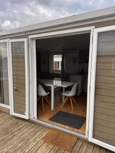 a sliding glass door on a patio with a table at Gemütliches Chalet in Strandnähe in Oostkapelle