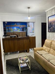 a living room with a couch and a fish tank at Hostel Anprado 4 kit café incluso, Próx-Aeroporto de Guarulhos in Guarulhos +15 photos