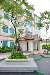 un arbre devant un bâtiment dans l'établissement Avion Hotel, à Lat Krabang