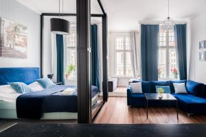 a bedroom with a mirror and a blue bed and a couch at Centrum Starówki Szeroka Komfort by Rentoom in Toruń