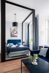 a bedroom with a blue bed and a large mirror at Centrum Starówki Szeroka Komfort by Rentoom in Toruń