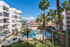 サン・バルトロメにあるApartamento Yumbo Atlantisのヤシの木が植わるアパートメント複合施設の空中ビュー