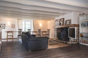 a living room with a couch and a fireplace at La Maison de la Grange in Moutiers-sur-le-Lay