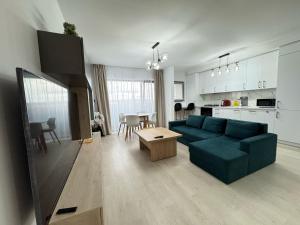 a living room with a blue couch and a kitchen at Ava Towers Accommodation 1-2 Bdm by GAP with Parking Option in Suceava