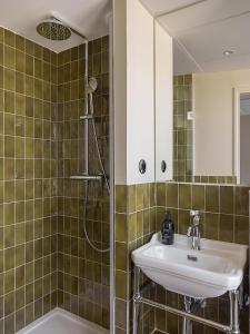 a bathroom with a sink and a shower at Hôtel du Savoir in Paris +26 photos