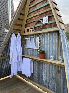 a shed with towels hanging on a wooden deck at Aframe Tiny Home SILVA with private hot tub in Cowes