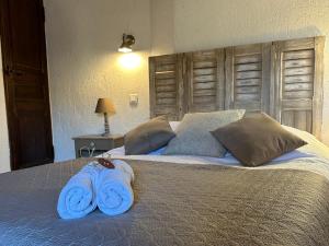 a large bed with two blue towels on it at La Maison des Hautures - Ancien Couvent avec Extérieur Proche Arénes- Idéal Familles ou groupe in Arles