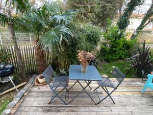 un tavolo blu con sedie e un vaso di fiori di LOFT Villa Anjou a Soulac-sur-Mer