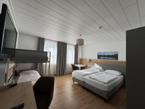 a hotel room with a bed and a flat screen tv at Landhotel Schlappinger-Hof in Reisbach