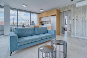 a living room with a blue couch and a kitchen at Avenue 101 2 BED in Paphos