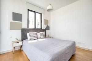 a white bedroom with a large bed and a window at Avenue 101 2 BED in Paphos