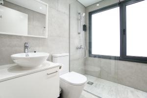 a bathroom with a sink and a toilet and a window at Avenue 101 2 BED in Paphos +9 photos