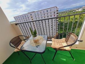 a table and two chairs on a balcony with a window at Paula' s cozy Haven in Lapu Lapu City