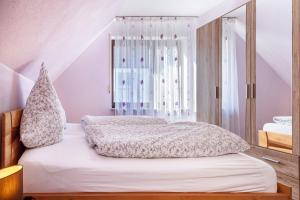 een slaapkamer met een bed en een raam bij Ferienwohnung bei Fredy in Langenargen