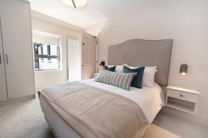 a white bedroom with a large bed and a window at Donegal Boardwalk Resort in Carrigart