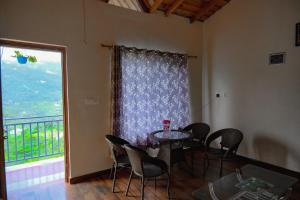 a dining room with a table and chairs and a window at Saanidhya Homestay in Mukteshwar