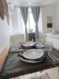 a dining room table with plates and glasses on it at Logement le gabian in Ampus