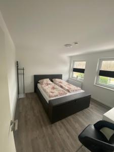 ein Schlafzimmer mit einem Bett, einem Stuhl und zwei Fenstern in der Unterkunft Motel Munsch in Neukirchen-Vluyn + 11 Fotos
