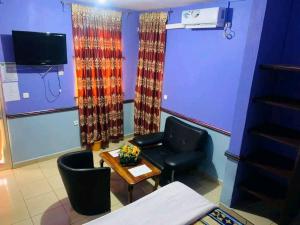 a waiting room with a chair and a table at Chambre spacieuse à SIDI in Bafoussam