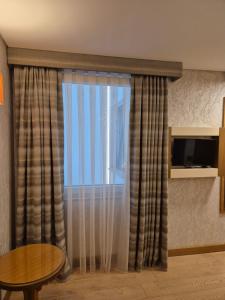a room with a window with curtains and a table at İstanbul Trend Hotel Old City in Istanbul