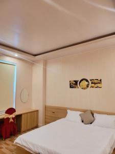 a bedroom with a white bed and a window at HOTEL Hưng Phát in Ha Tinh