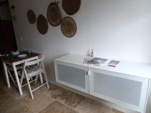 a white counter in a room with a table and a stool at Logement le gabian in Ampus