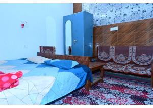 Shree Rajaram Homestay I Nearby Ram Mandir I Ayodhya في Ayodhya: غرفة نوم بها سرير وكرسيين وخزانة زرقاء