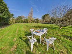 une table et des chaises dans un champ herbeux avec une table et des chaises dans l'établissement Agréable maison avec grand jardin pour 4, à Saint-Jean-Trolimon