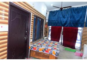 Shree Rajaram Homestay I Nearby Ram Mandir I Ayodhya في Ayodhya: غرفة نوم بسرير وباب مع ستائر +54 صورة