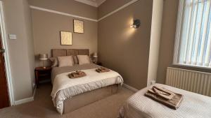 a bedroom with two beds with towels on them at Hotel Sofia Blackpool in Blackpool