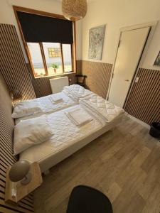 a large bed in a room with a window at Folsted - Værelse 100 med eget badeværelse og fri parkering in Bindslev