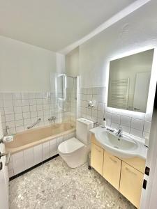 a bathroom with a toilet and a sink and a tub at Basel & Frankreich nah - Airport I Parking I WLAN in Herten +18 photos
