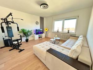 a living room with a white couch and a tv at Basel & Frankreich nah - Airport I Parking I WLAN in Herten