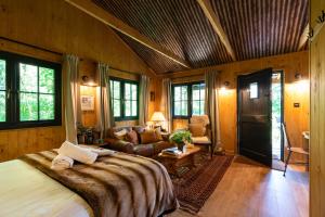 a bedroom with a large bed and a living room at Luxury Off-Grid Cabin with Outdoor Bath in Scotland in Clachan of Campsie