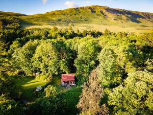 an aerial view of a house in the middle of a forest at Luxury Off-Grid Cabin with Outdoor Bath in Scotland in Clachan of Campsie