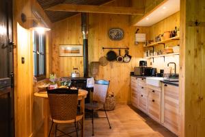 a kitchen with wooden walls and a table and chairs at Luxury Off-Grid Cabin with Outdoor Bath in Scotland in Clachan of Campsie