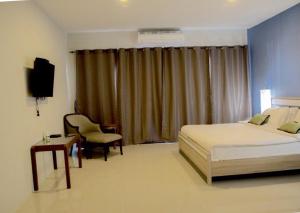 a bedroom with a bed and a desk and a television at Chill Days @ Koh Larn in Ko Larn