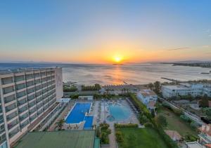 an aerial view of a hotel and the ocean at sunset at Divani Apollon Palace & Thalasso in Athens +37 photos