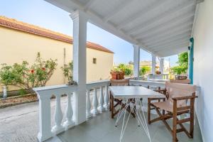 a patio with a table and chairs on a balcony at Pleasure Corfù Fish in Agios Georgios