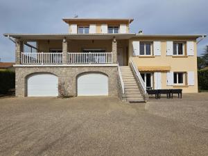 a large house with a balcony and two garage doors at Maison avec terrasse Davézieux in Davézieux