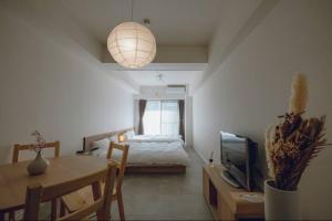 a bedroom with a bed and a table and a dining room at Coda House in Aoichō