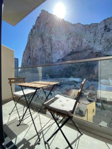 a table and chairs on a balcony with a mountain at Studio Apartment at the Hub - VIP Package in Gibraltar