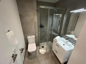 a bathroom with a shower and a toilet and a sink at Studio Apartment at the Hub - VIP Package in Gibraltar